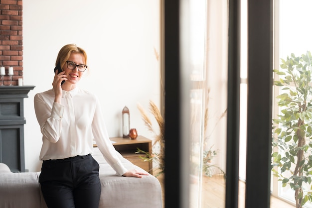 Mujer de negocios rubia que habla en el teléfono