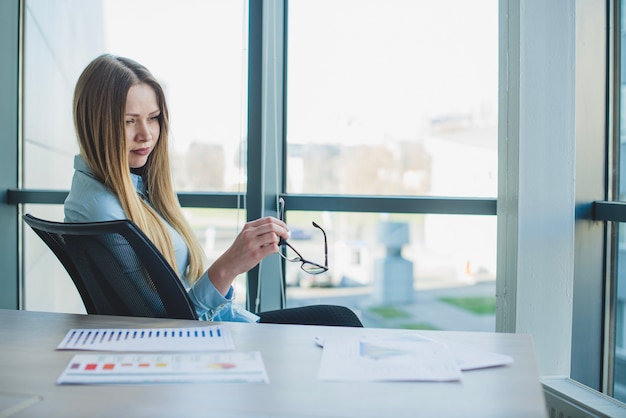 Foto gratuita mujer de negocios rubia en una silla