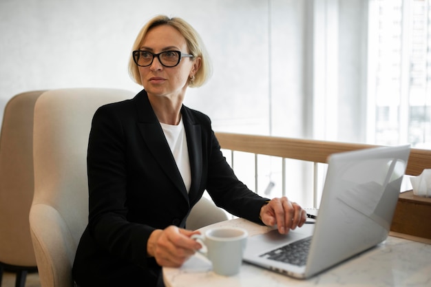 Mujer de negocios rubia trabajando en su computadora portátil