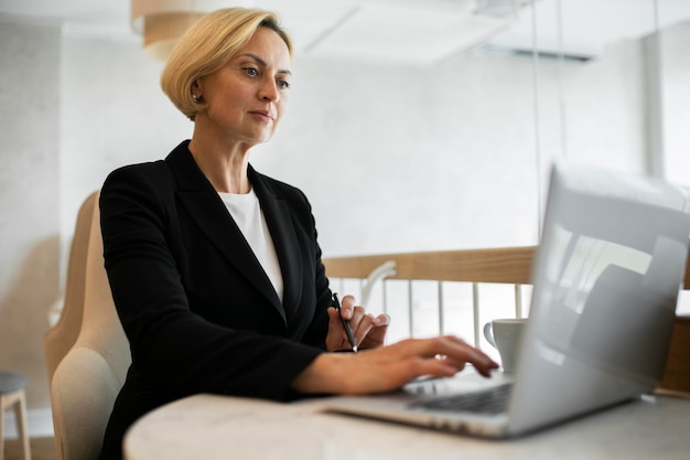 Mujer de negocios rubia trabajando en su computadora portátil