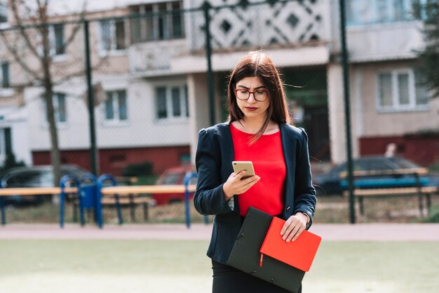 Mujer de negocios con smartphone al aire libre