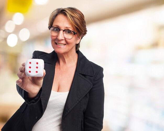 Mujer de negocios sonriendo con un dado