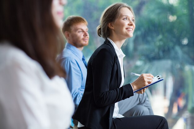 Mujer de negocios sonriendo tomando apuntes