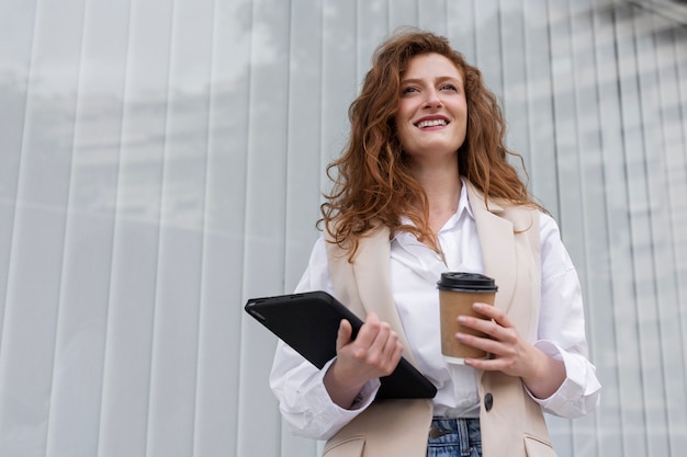 Mujer de negocios sonriente de ángulo bajo