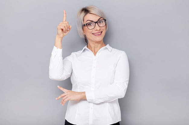 Foto gratuita mujer de negocios sonriente apuntando arriba