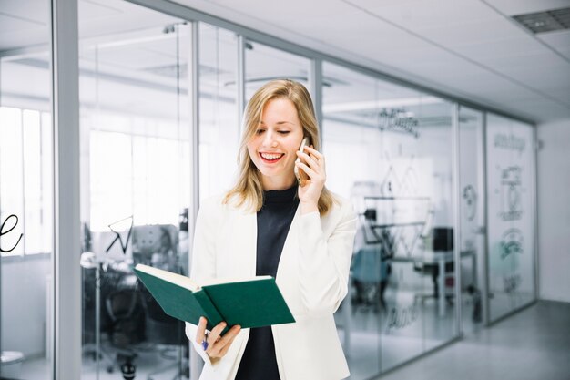 Mujer de negocios sonriente con libro