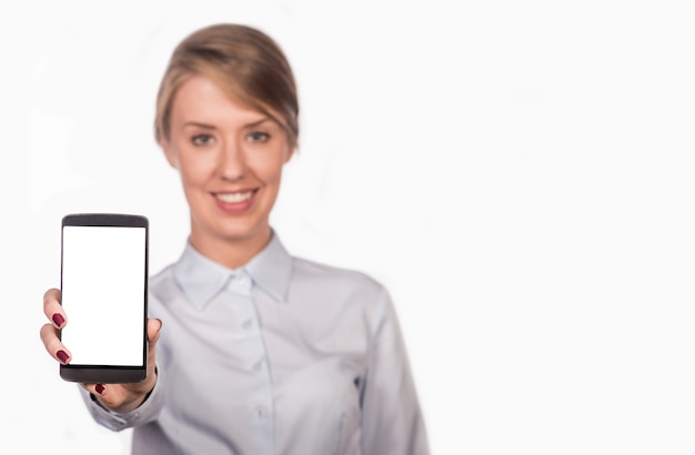 Mujer de negocios sonriente mostrando una pantalla en blanco del teléfono inteligente aislado en un fondo blanco. Bonita mujer bonita mostrando una pantalla en blanco del teléfono inteligente