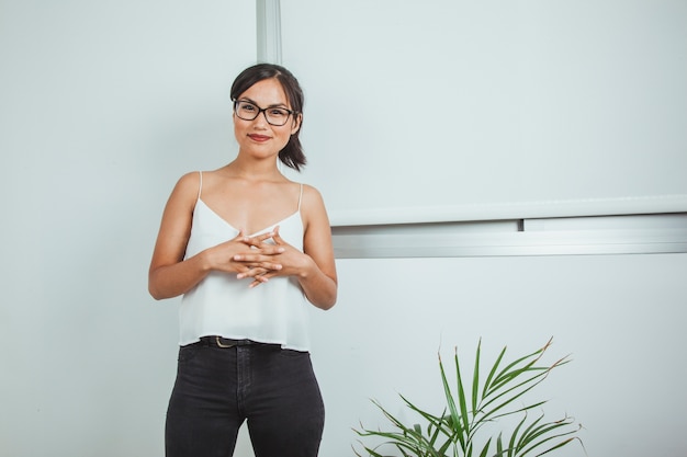 Mujer de negocios sonriente posando con las manos juntas