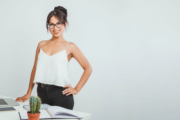 Mujer de negocios sonriente posando con su escritorio