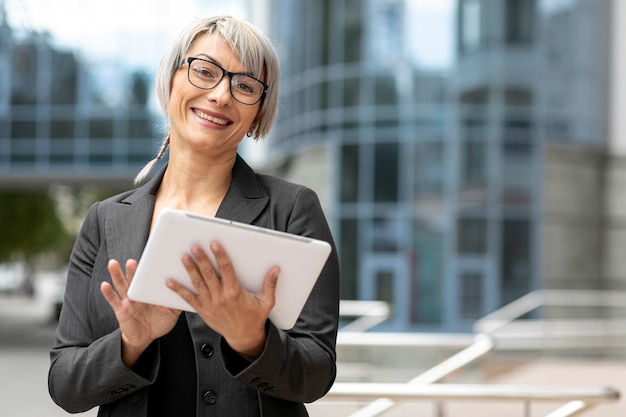 Foto gratuita mujer de negocios sonriente que usa la tableta