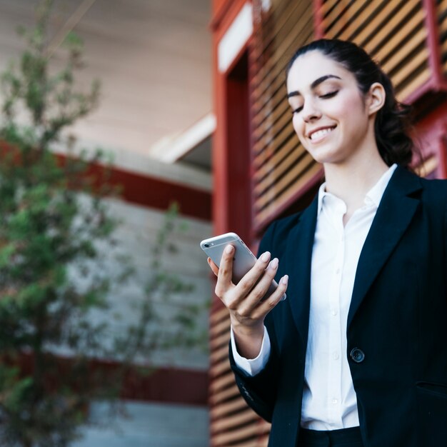 Mujer de negocios sonriente con smartphone