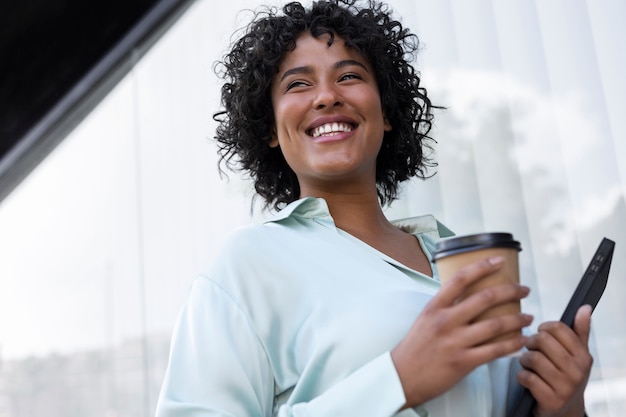 Mujer de negocios sonriente sosteniendo una taza de café