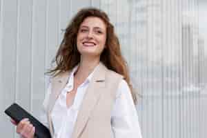 Foto gratuita mujer de negocios sonriente con vista lateral de la tableta