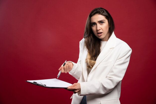 Mujer de negocios sosteniendo un cuaderno abierto