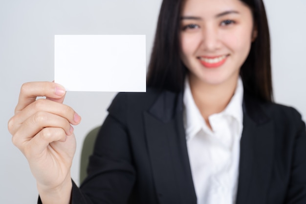 mujer de negocios sosteniendo y mostrando tarjeta vacía o tarjeta de presentación