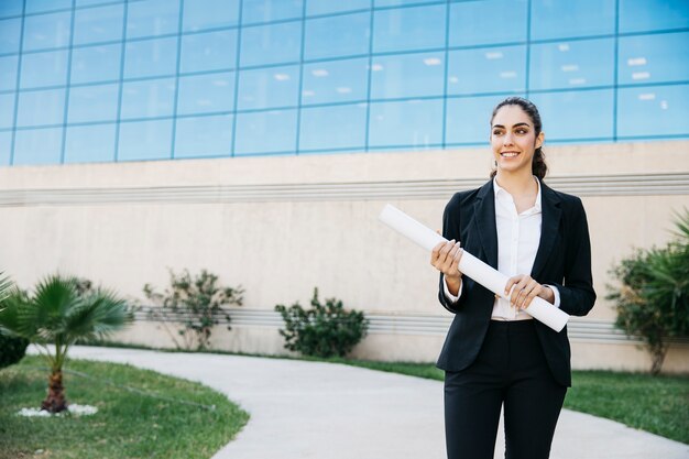 Foto gratuita mujer de negocios sujetando plano