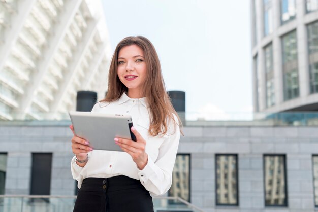 Mujer de negocios con una tablet en la calle