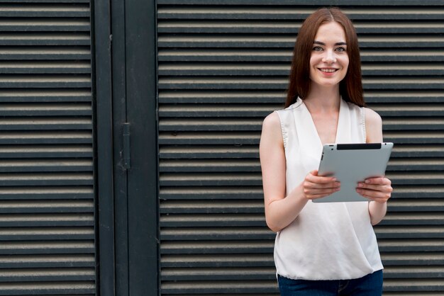 Mujer de negocios con una tablet en la calle