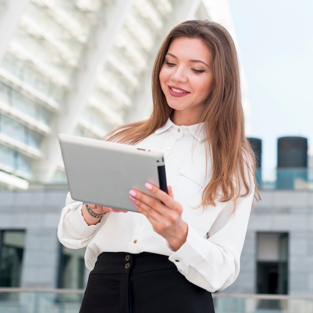 Mujer de negocios con una tablet en la calle