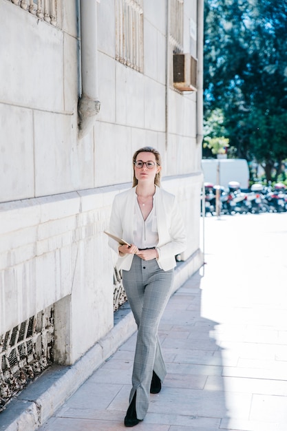 Mujer de negocios con tableta en la calle