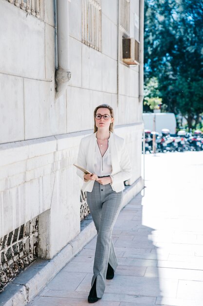 Mujer de negocios con tableta en la calle