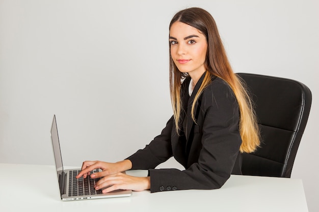 Mujer de negocios tecleando y posando