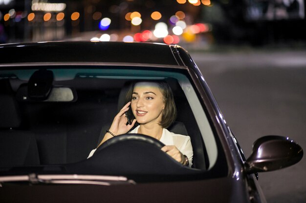 Mujer de negocios con el teléfono en el coche