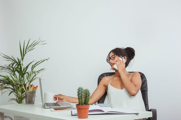 Mujer de negocios con teléfono y taza de café