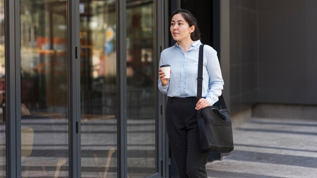 Mujer de negocios de tiro medio con café