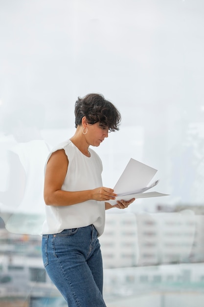 Mujer de negocios de tiro medio con documentos