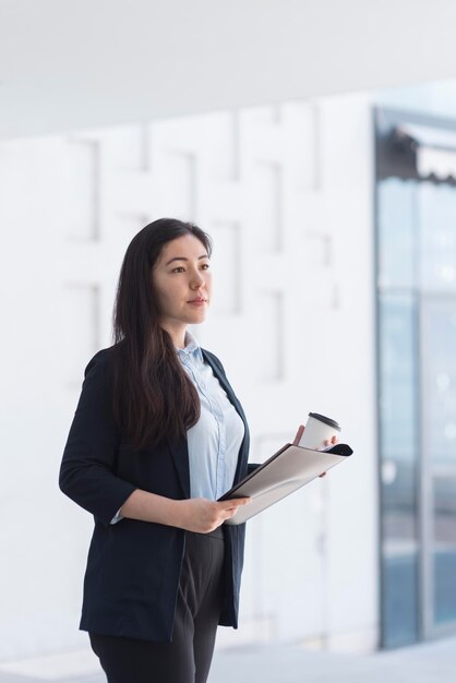 Mujer de negocios de tiro medio mirando lejos