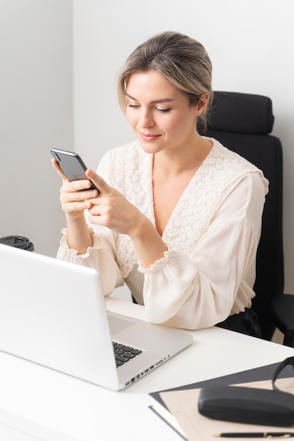 Foto gratuita mujer de negocios de tiro medio sosteniendo teléfono