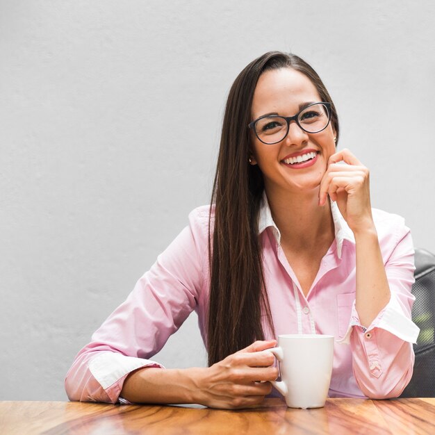 Mujer de negocios de tiro medio con una taza de café.