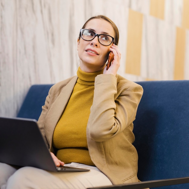 Mujer de negocios de tiro medio en el teléfono