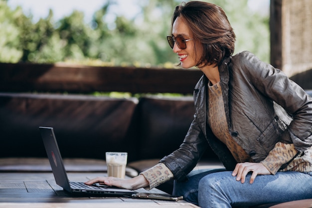 Mujer de negocios trabajando en la computadora portátil fuera de casa