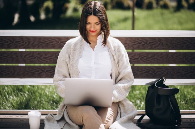 Mujer de negocios trabajando en la computadora portátil fuera del parque