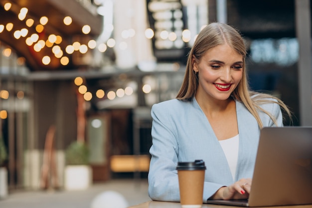 Foto gratuita mujer de negocios trabajando en equipo en un café y tomando café