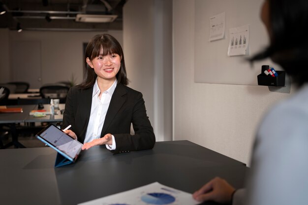 Foto gratuita mujer de negocios trabajando en ipad tiro medio