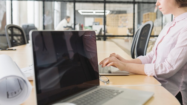 Mujer de negocios trabajando con portátil en oficina