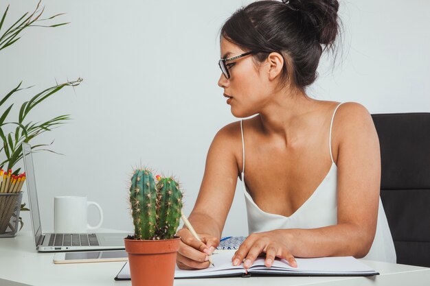 Mujer de negocios en el trabajo escribiendo en su cuaderno