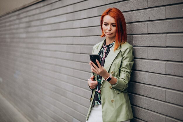 Mujer de negocios en traje verde de pie con carpeta