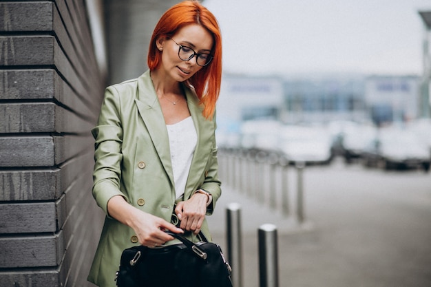 Foto gratuita mujer de negocios en traje verde de pie junto a la pared