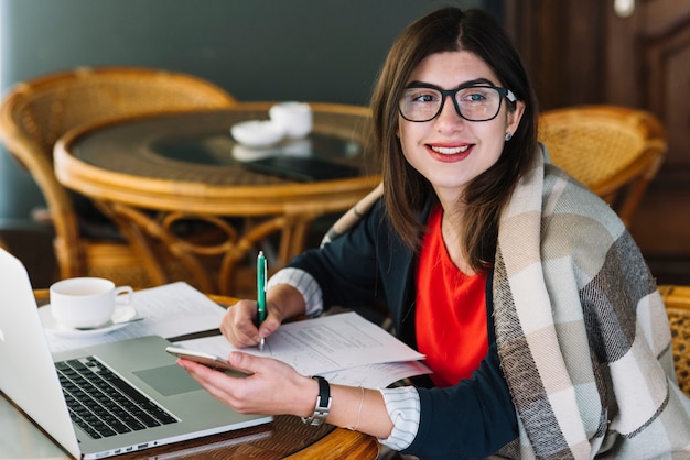 Mujer de negocios usando portátil en cafetería