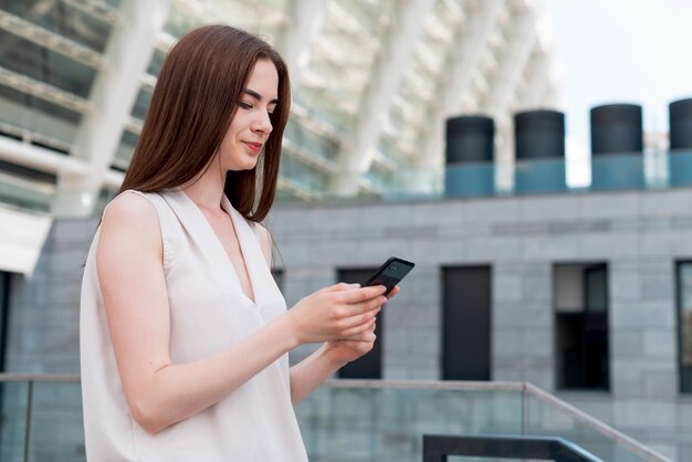 Mujer de negocios usando smartphone en la calle