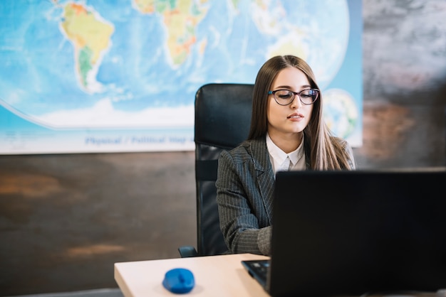 Mujer de negocios, usar la computadora portátil, en la mesa