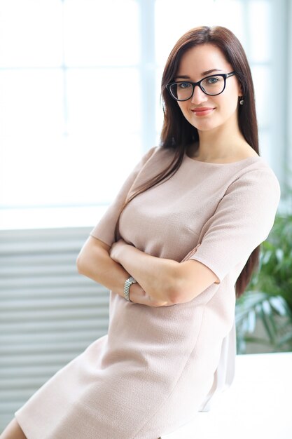 Mujer de negocios en vestido beige de oficina