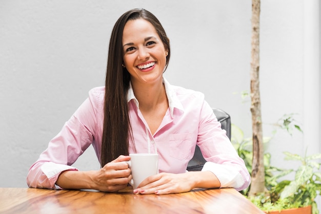 Mujer de negocios de la vista delantera con una taza de café