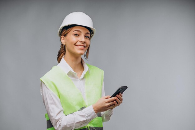 Mujer de negocios vistiendo chaleco y casco hablando por teléfono