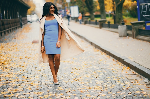 Mujer negra caminando en una ciudad de otoño