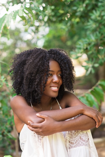 Mujer negra joven feliz que se relaja en parque